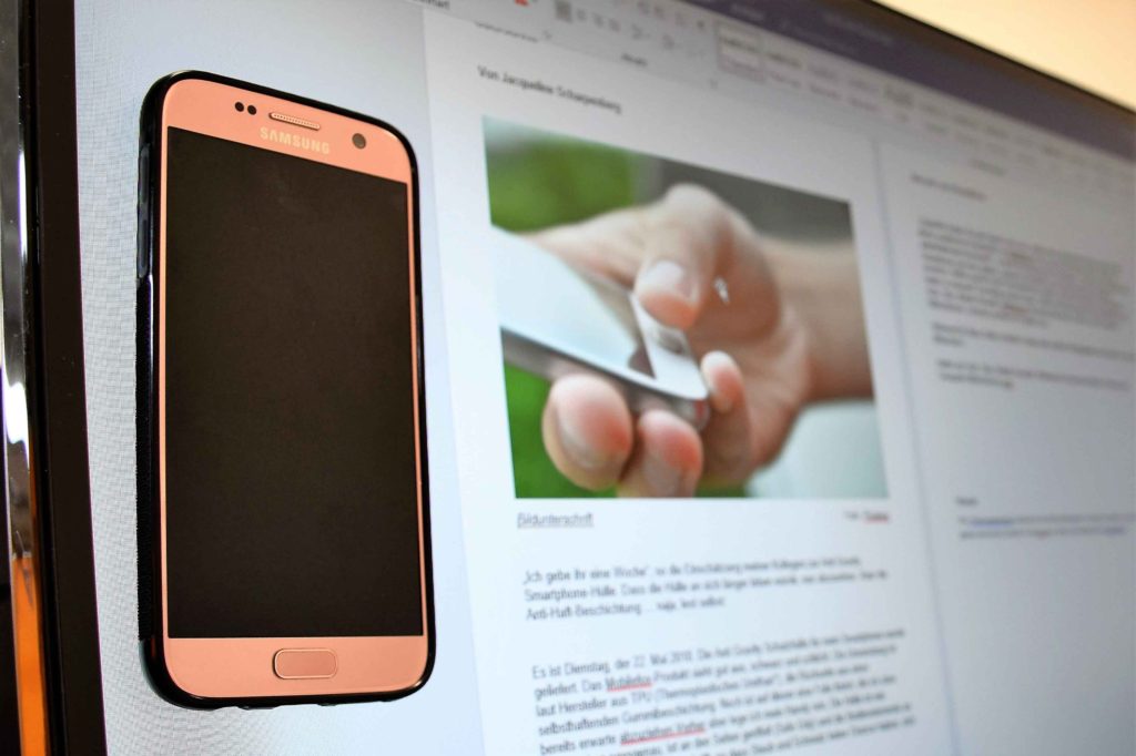 Smartphonehülle haftet am Computer-Bildschirm. Haftet am Computer-Bildschirm dank Anti Gravity Beschichtung
